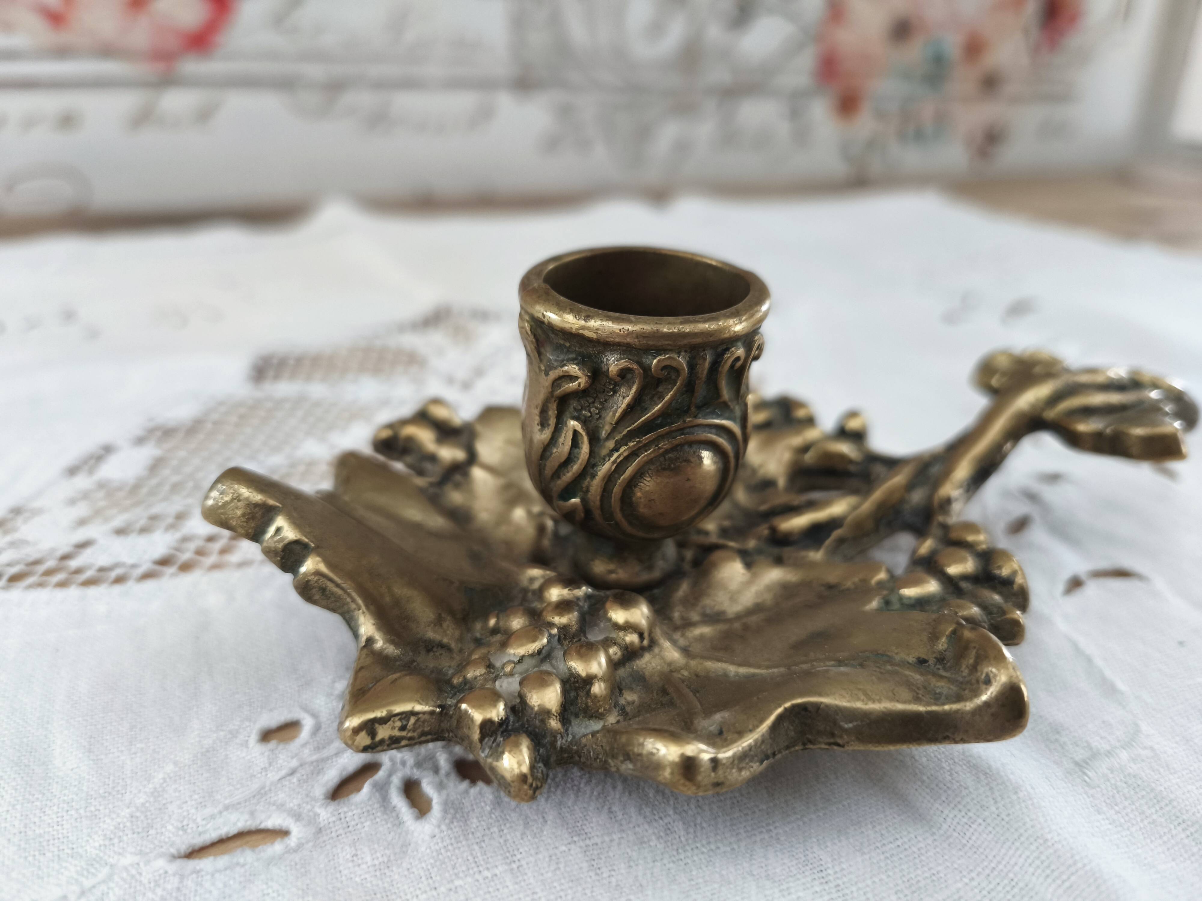 Hand-held candle holder called "cellar rat" in brass with vine leaf decoration