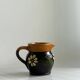 Petit pichet Alsacien en céramique noire et marron, décoré de motifs floraux peints à la main.