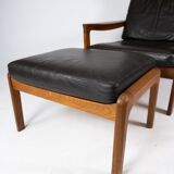 Easy chair with stool in teak upholstered with black leather design Arne Wahl Iversen