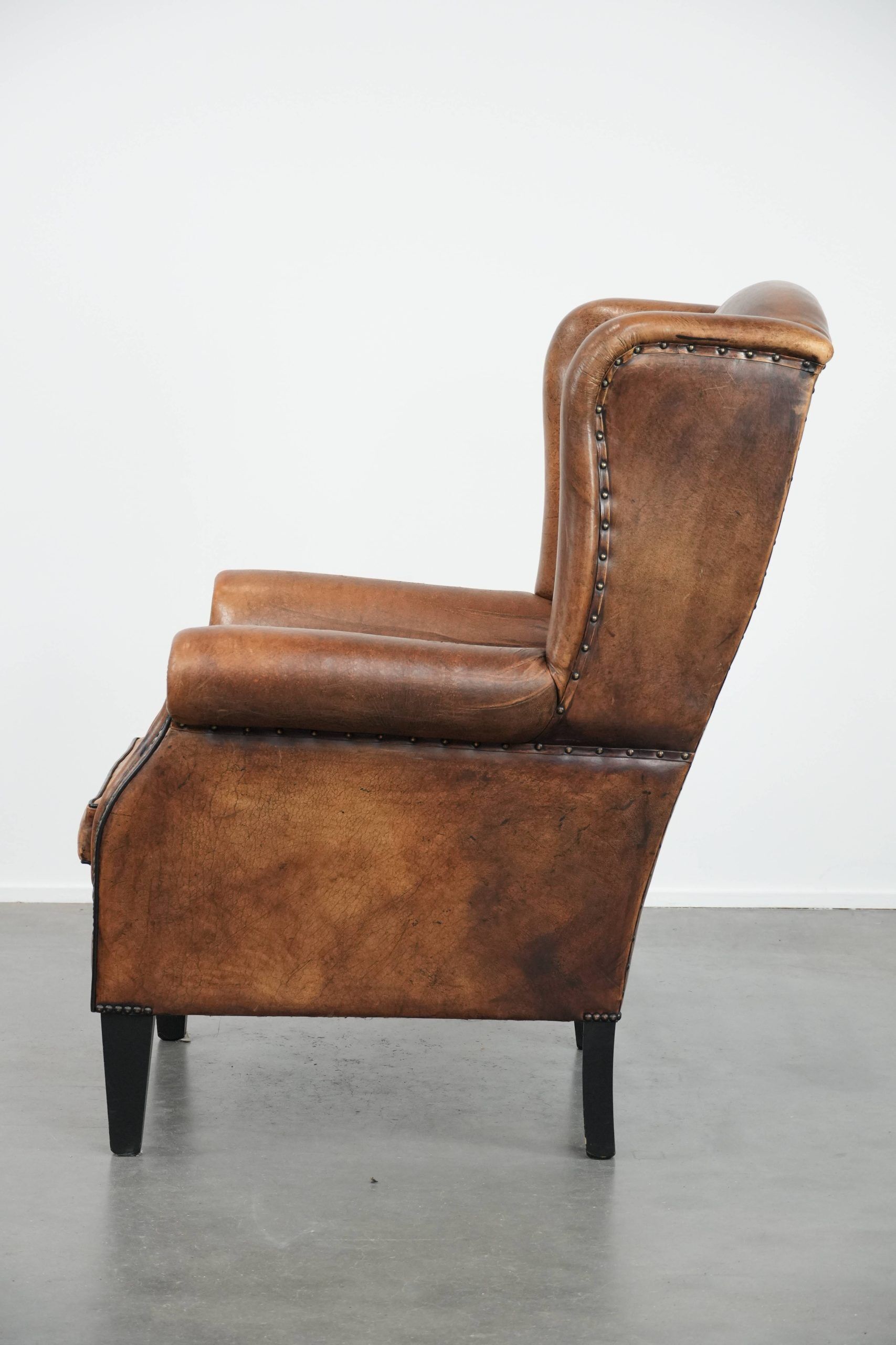 Large and comfortable sheepskin leather wingback chair with black piping
