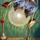 Vintage lamp with brass leaf design and transparent glass globe.