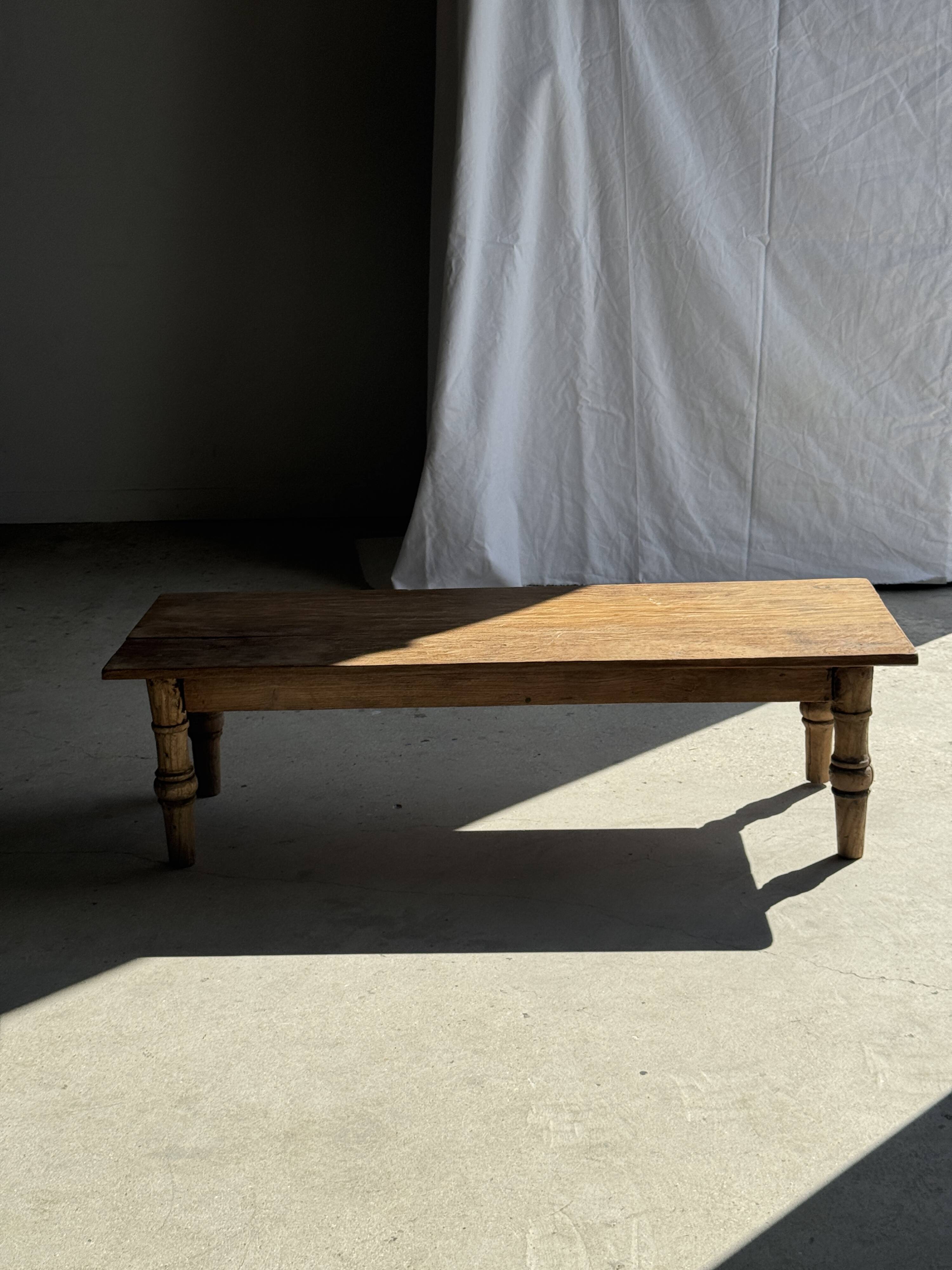Brown Indonesian teak coffee table, with a border and cylindrical legs H40 L103.