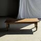 Brown Indonesian teak coffee table, with a border and cylindrical legs H40 L103.