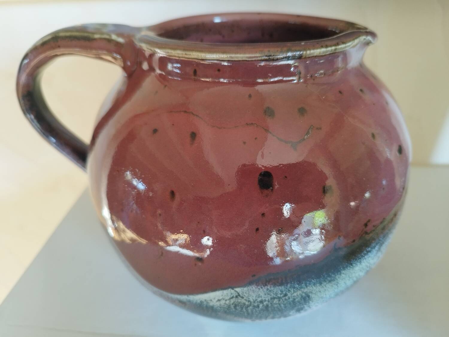 Stoneware pitcher by Matthieu Liévois in shades of red