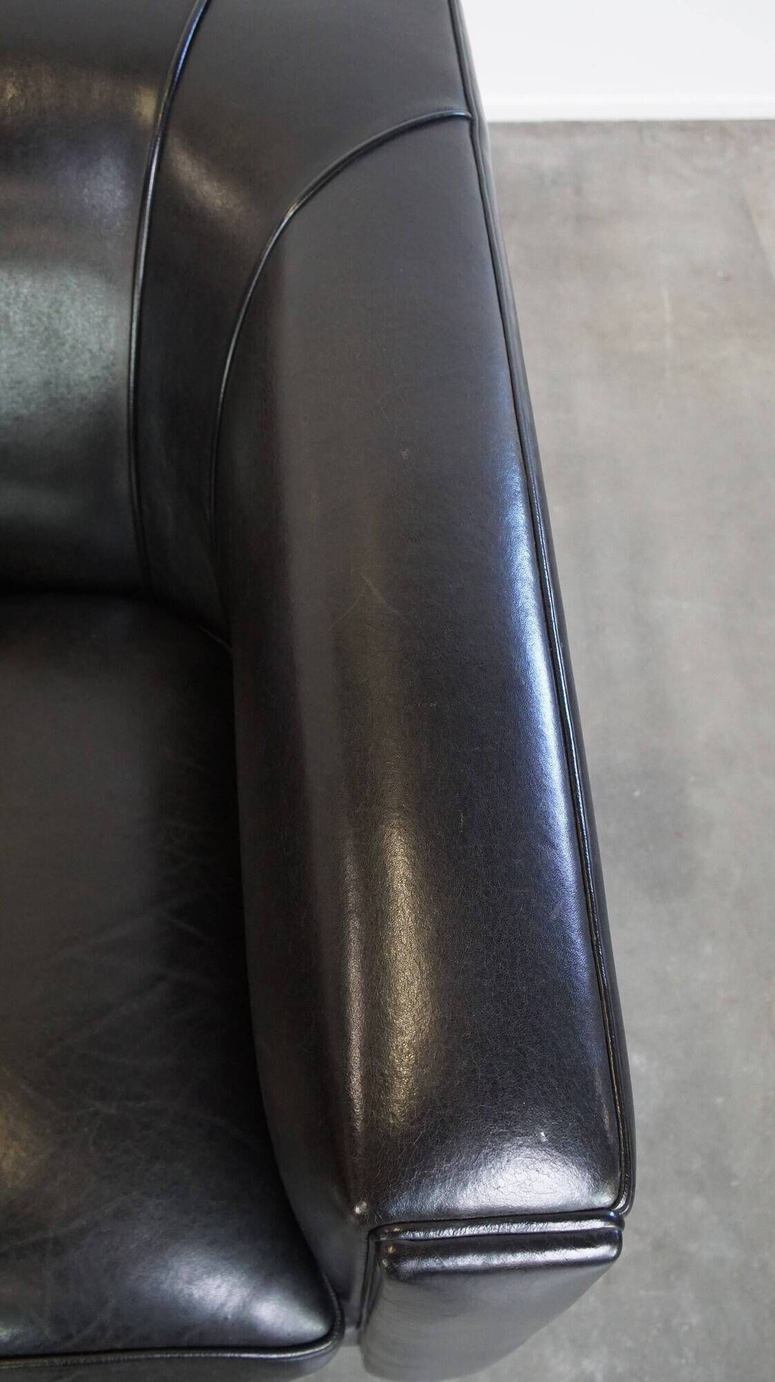 Very comfortable black Art Deco design armchair, made of sheepskin leather