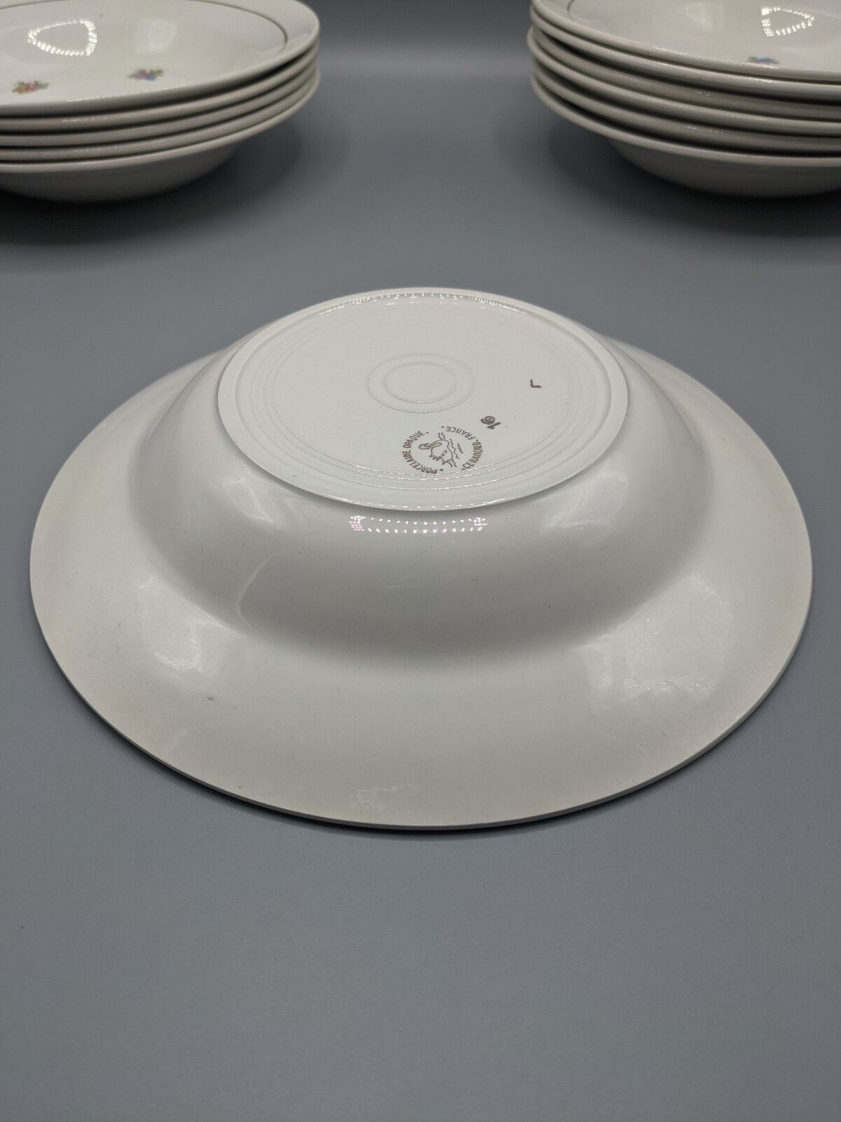 12 hollow porcelain plates, floral decoration and golden ledé - ∅: 23cm