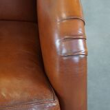 Cognac-colored sheepskin armchair with rounded shapes