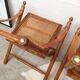 Pair of folding chairs in bamboo and caning, leather and brass