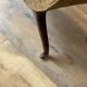Antique brown recamier armchair in fabric and wood, S-shaped silhouette and turned legs.