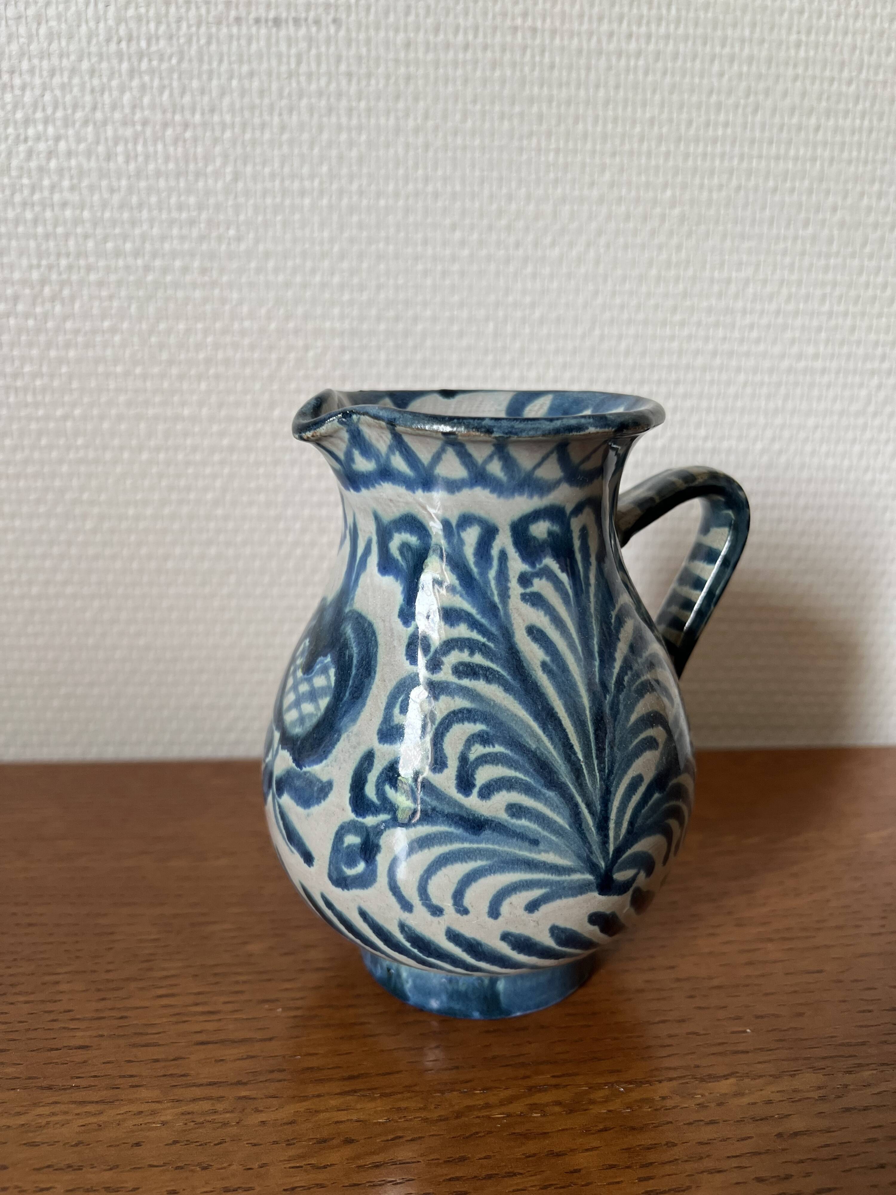 Blue ceramic pitcher with floral patterns