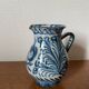 Blue ceramic pitcher with floral patterns