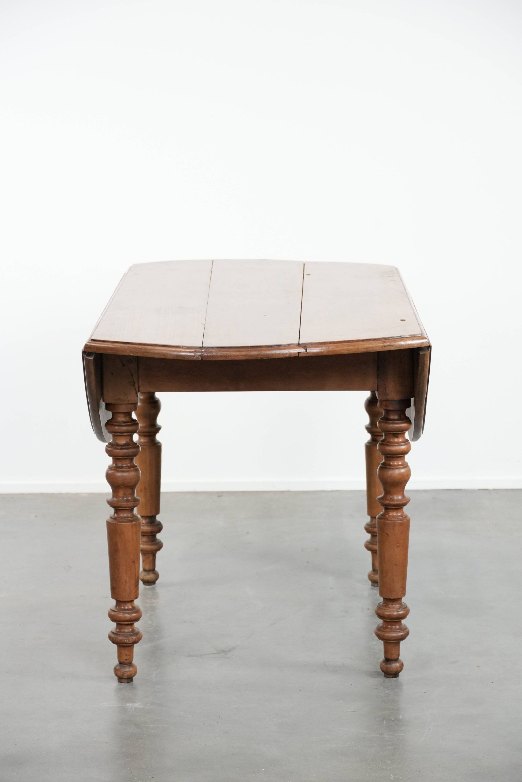 Antique English drop-leaf dining table made of walnut with elegant legs