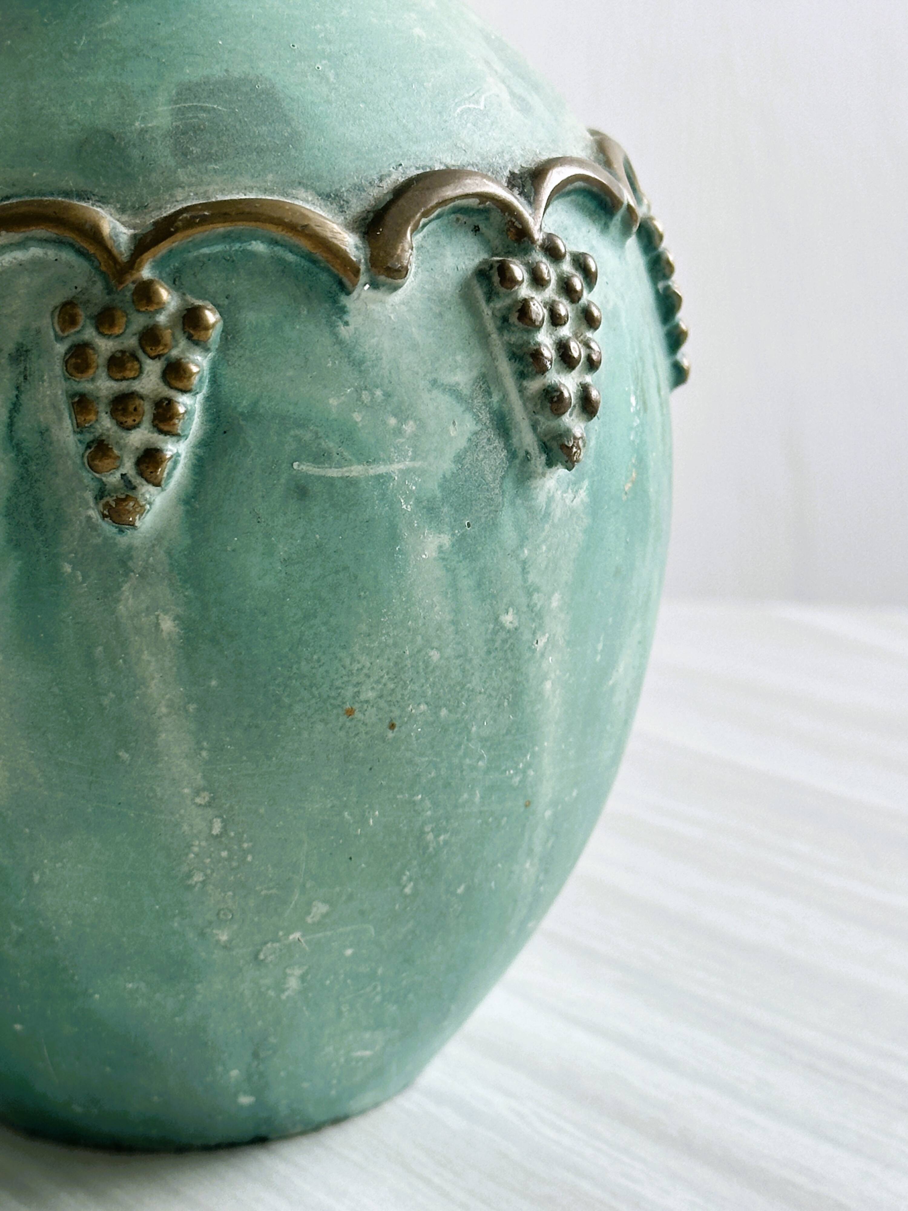 Brass vase decorated with bunches of grapes.