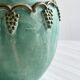 Brass vase decorated with bunches of grapes.