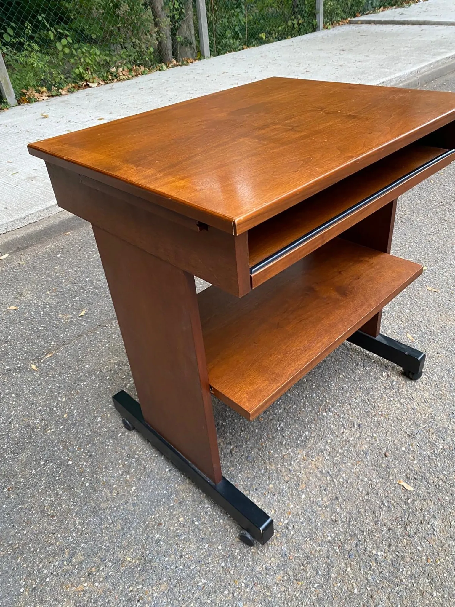Small Scandinavian-style computer desk on wheels made of wood.