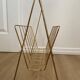 Vintage magazine rack in gold metal with white plastic handle. 60s.