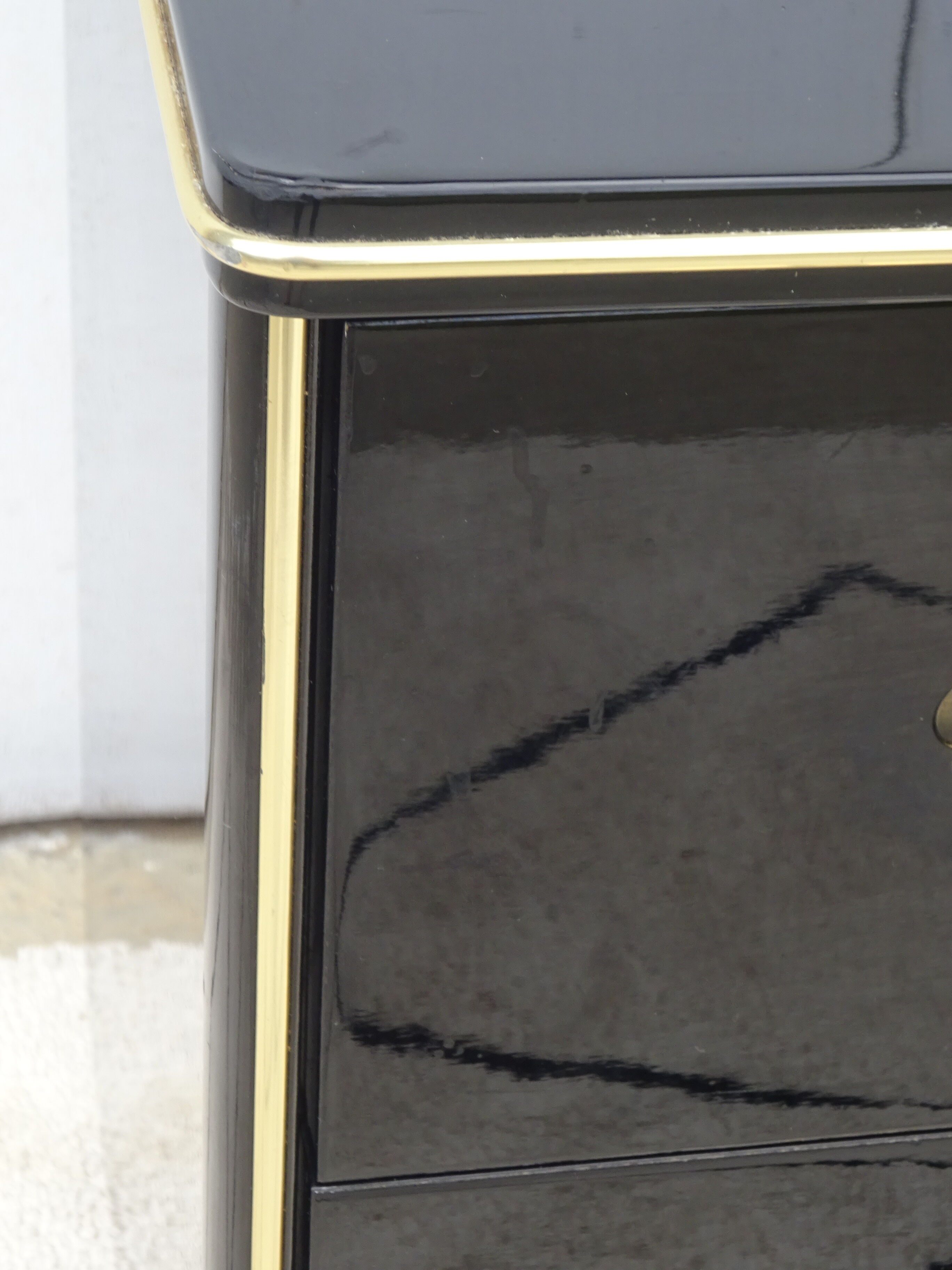 Lacquered black chest of drawers, golden brass