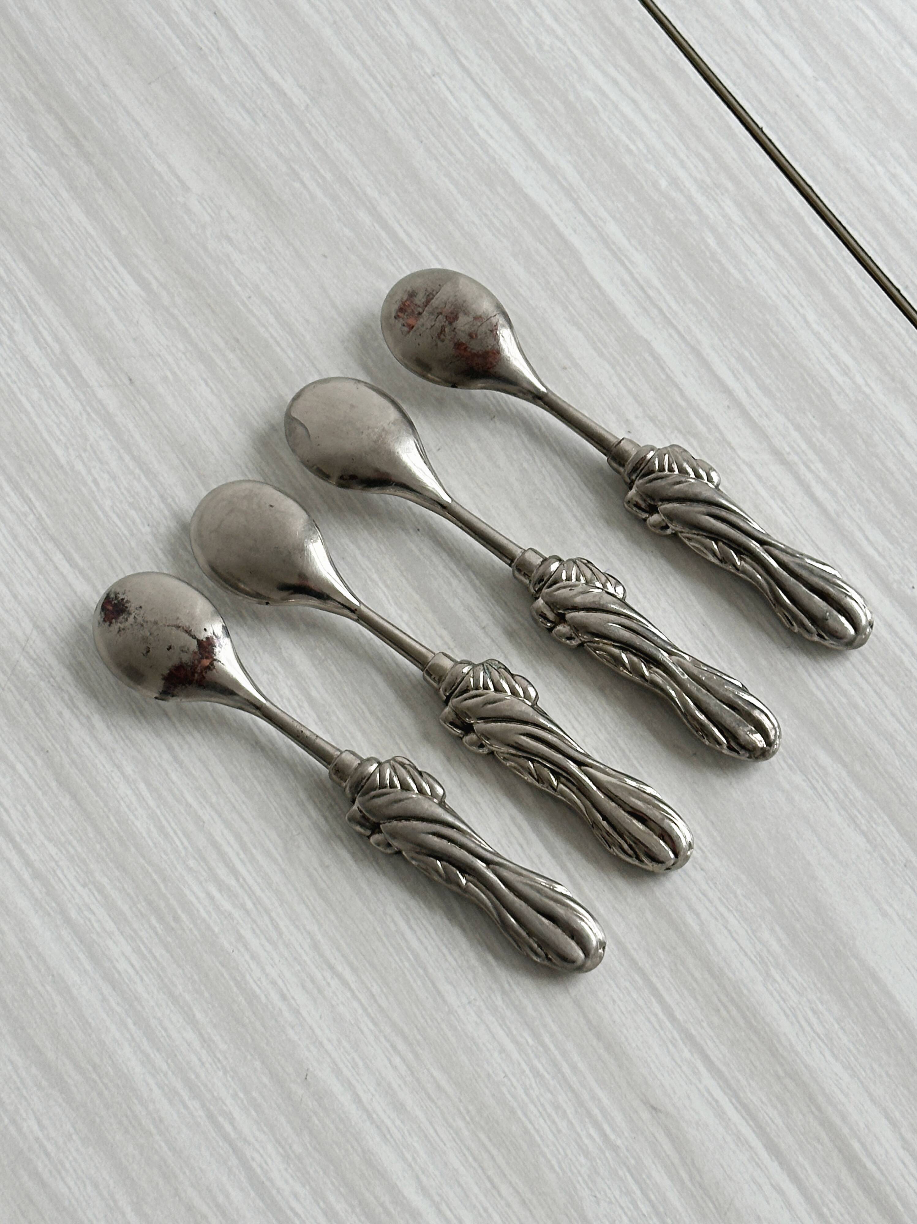 Antique small spoons with a metal bow design