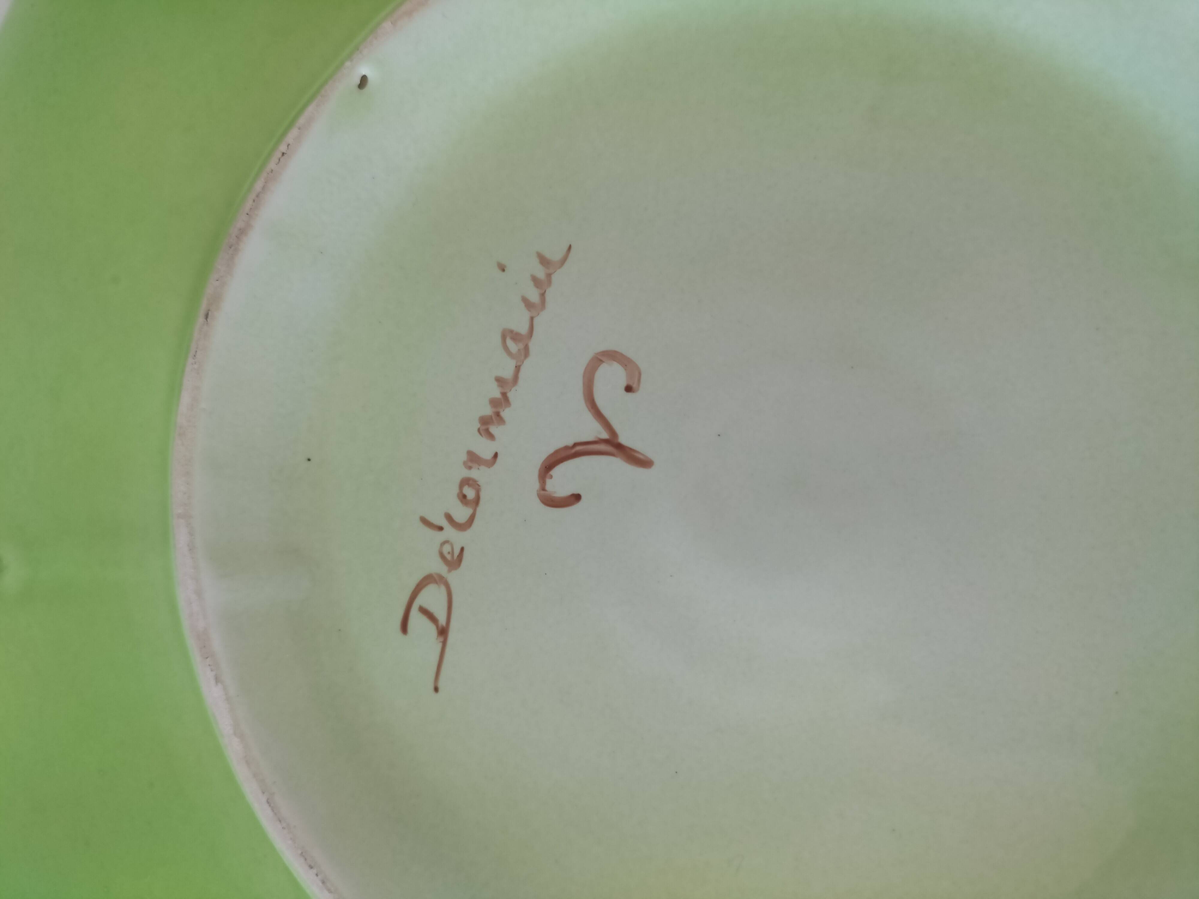 4 hand-decorated earthenware plates with vegetable and green leaf designs.