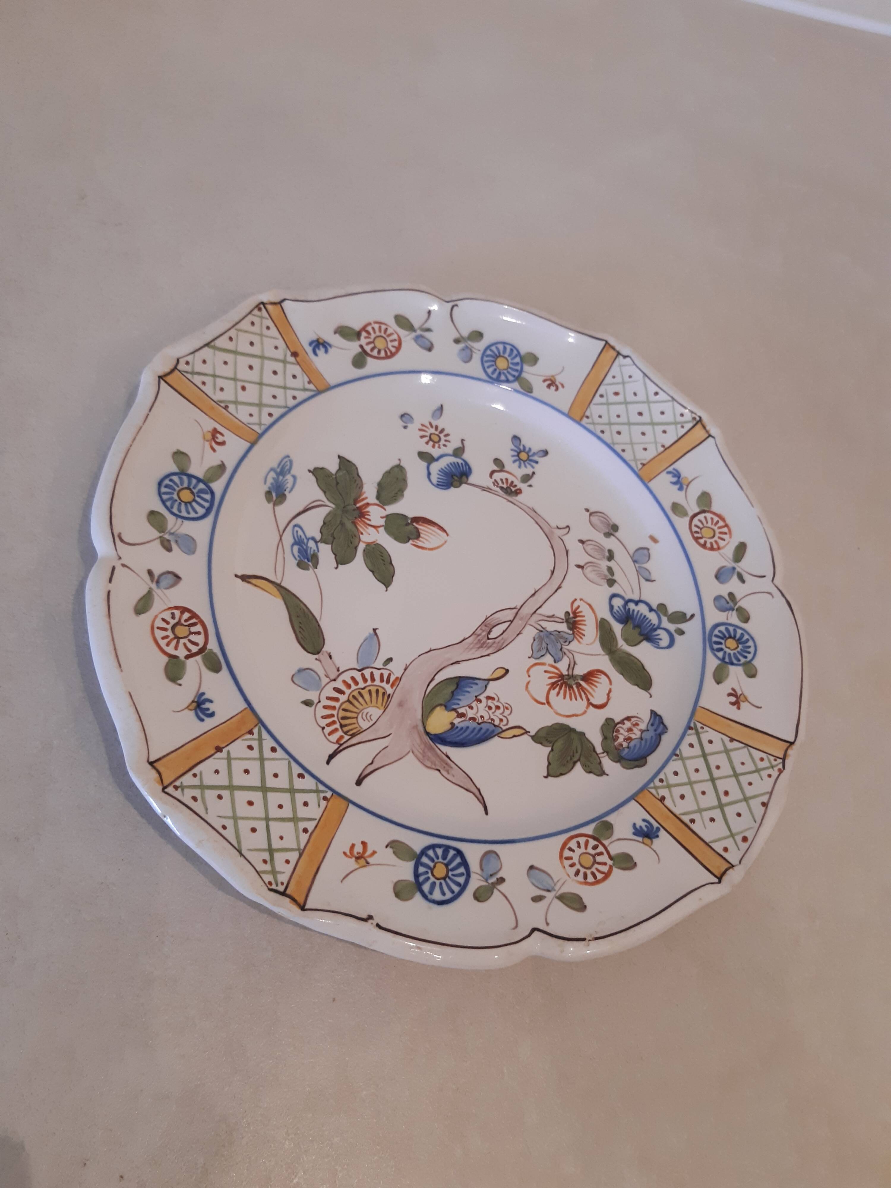 Flat plate in earthenware, hand-painted rural decoration partly in relief,