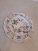 Flat plate in earthenware, hand-painted rural decoration partly in relief,