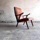 Vintage armchair from the 1950s in cognac leather and dark wood — modernist lounge chair.