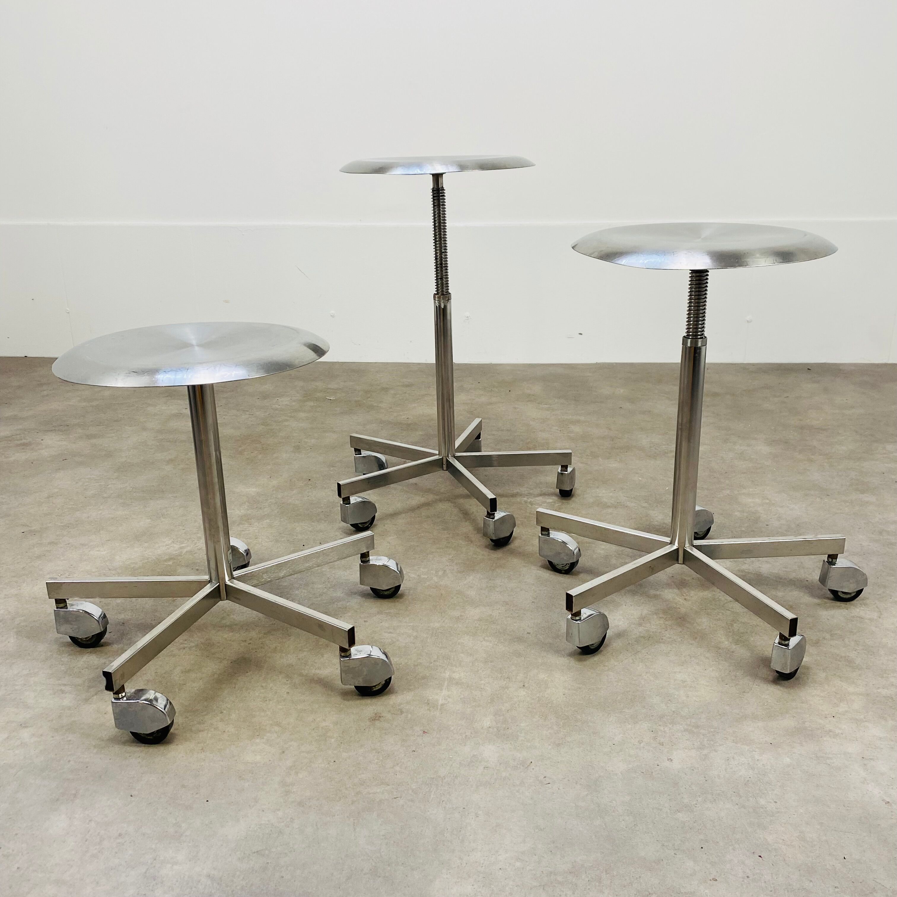 3 adjustable industrial stools with aluminum wheels