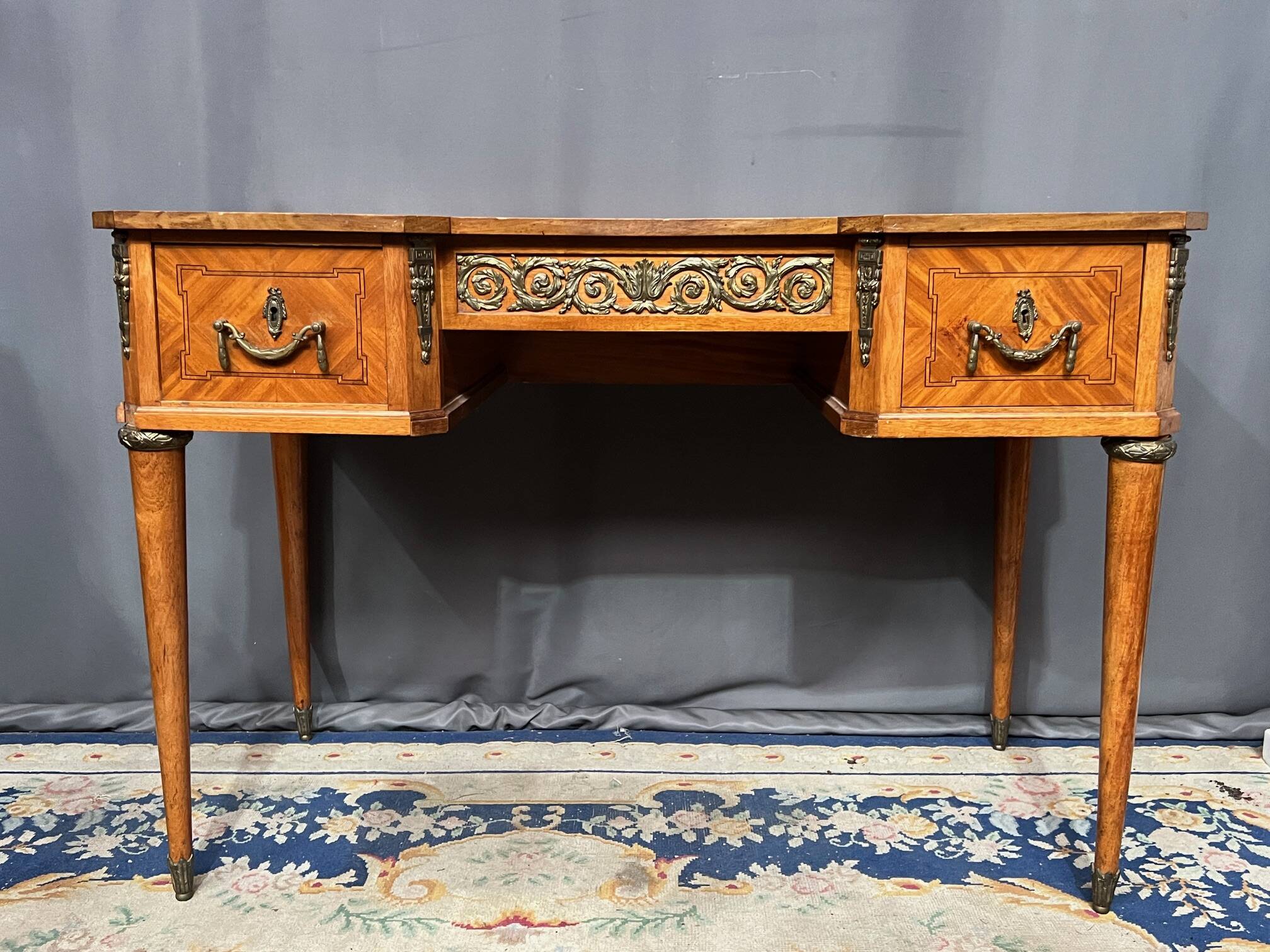 Louis XVI style marquetry desk. The top is decorated with green leather.