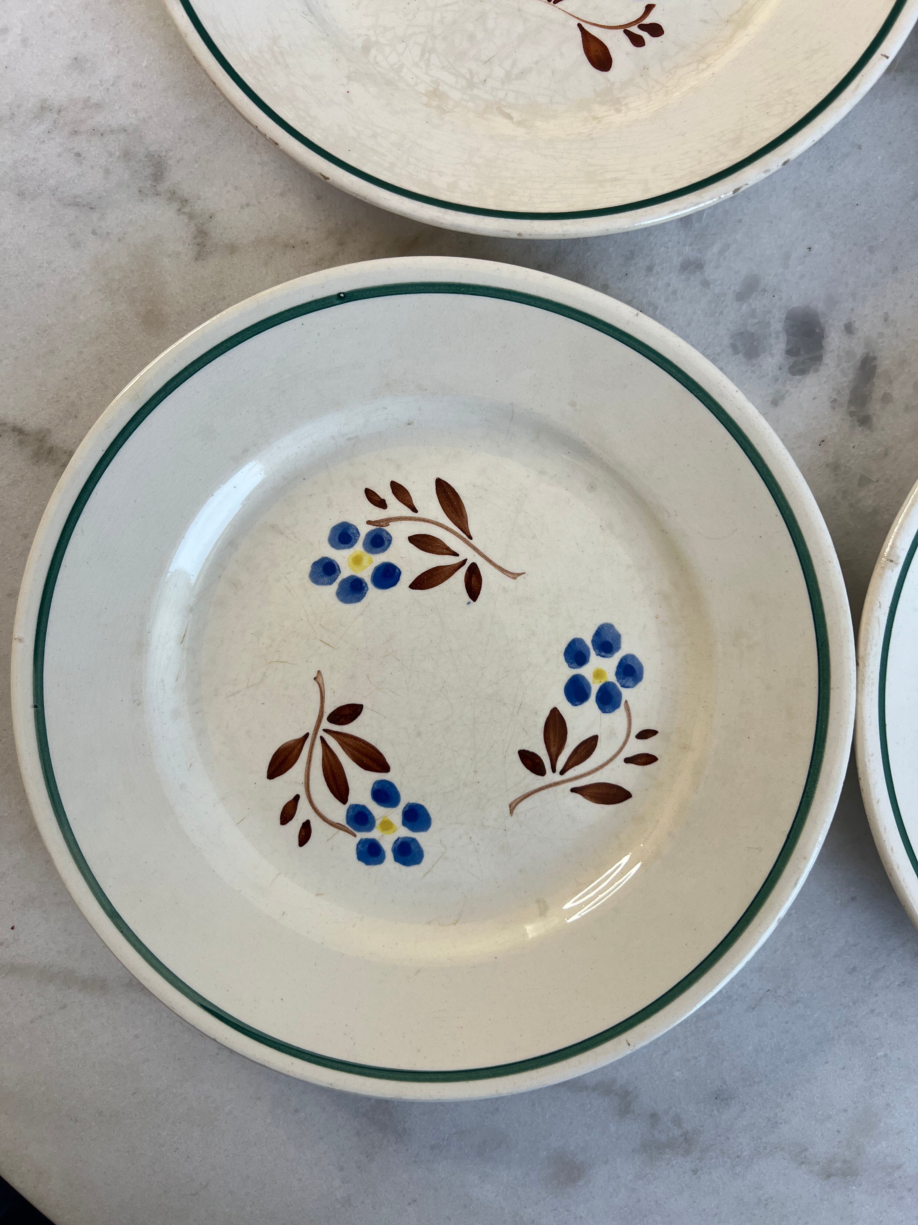 Set of 4 small flat plates with floral designs.