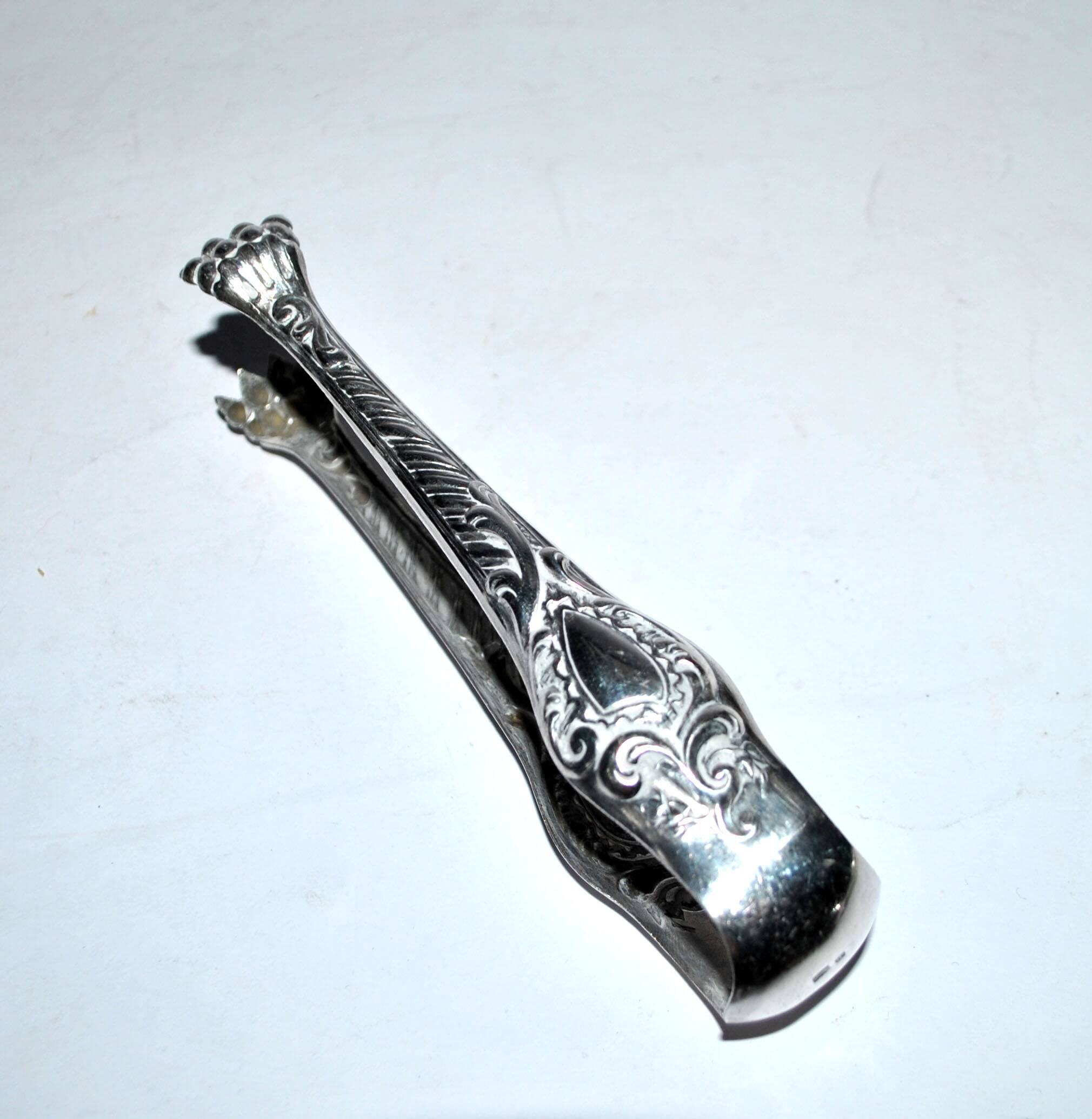 Rocaille sugar tongs in silver metal with lion claw medallion