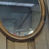 Louis XVI-style oval mirror in gilded stucco circa 1900