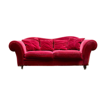 Three-seater velvet sofa in red.