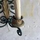 Pair of wall sconces in wrought iron with golden leaf patterns.