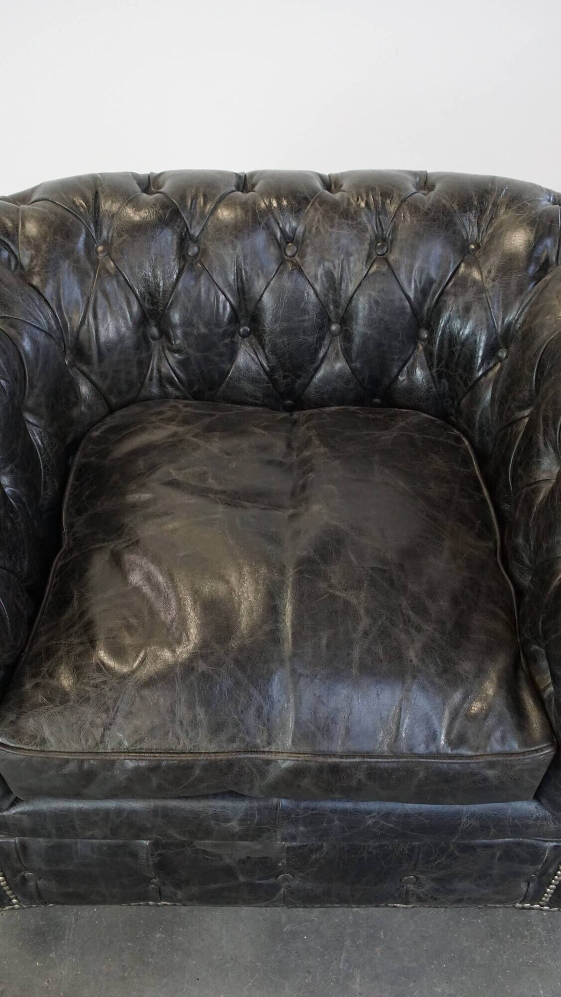 Spacious black cow leather chesterfield armchair with distinctive character