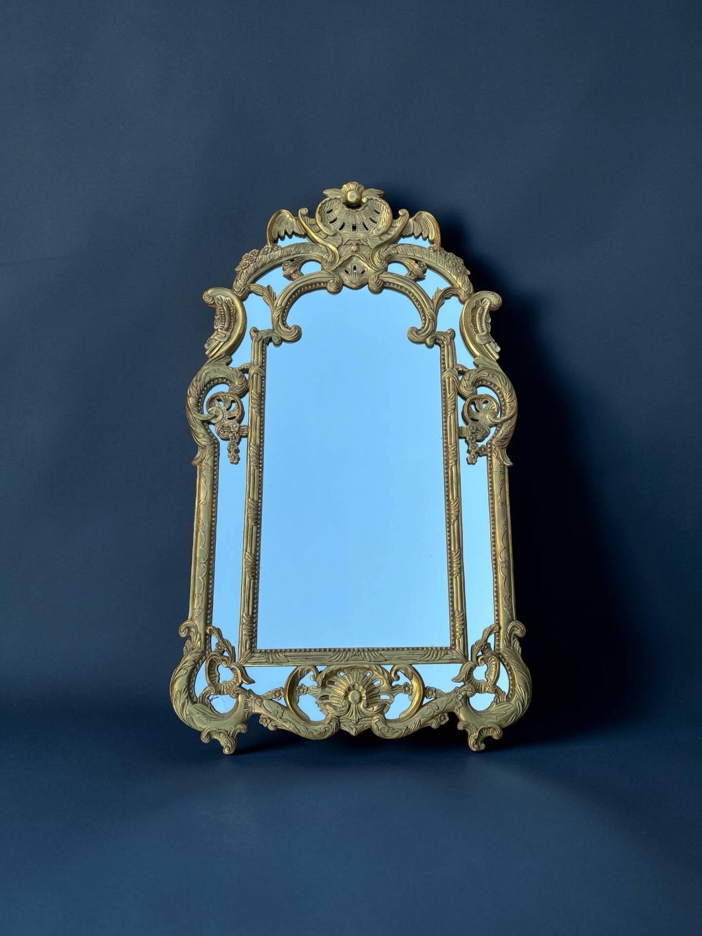 Large mirror with carved and gilded wooden frame, in Regency style.