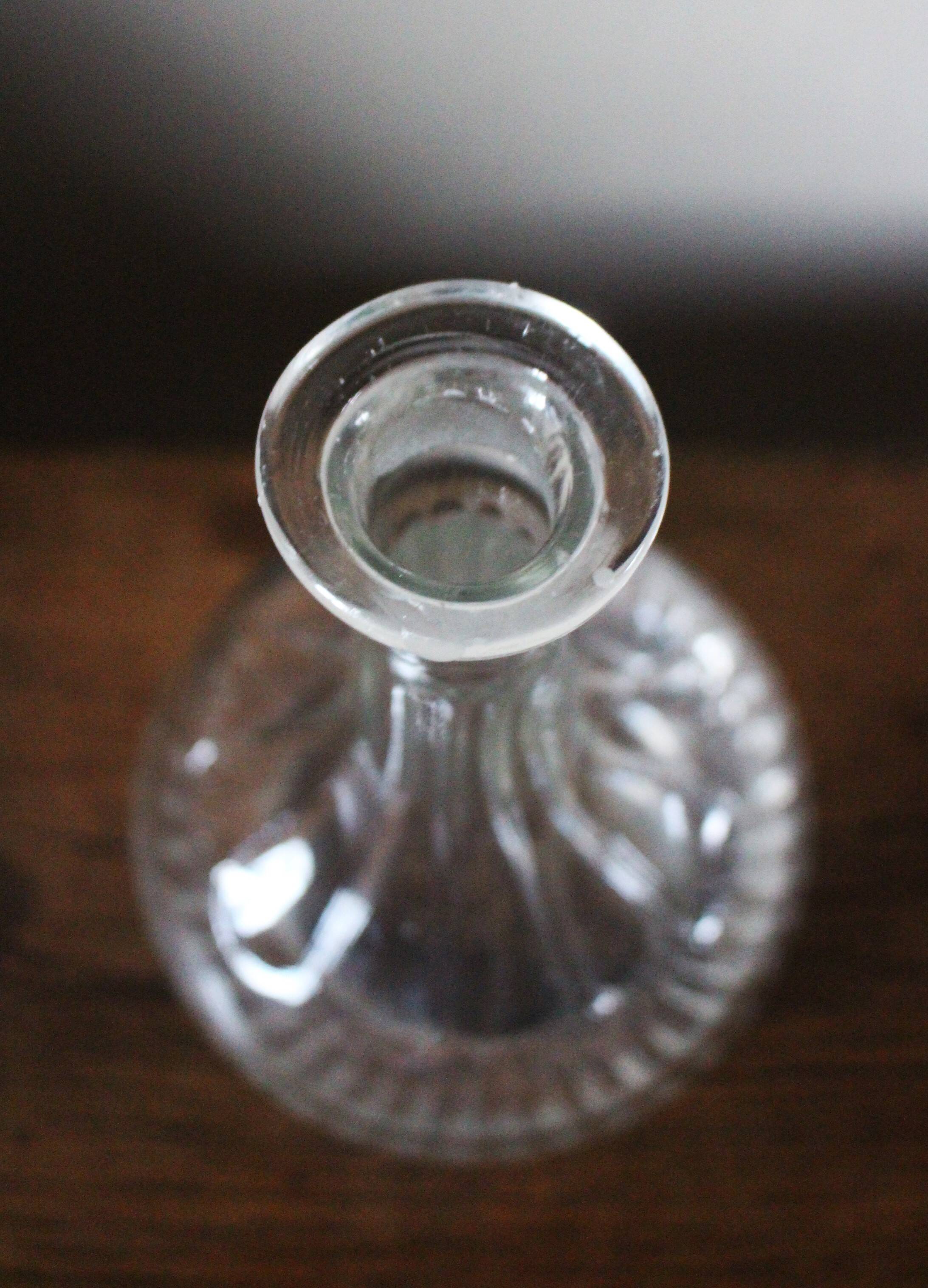 Round-bellied glass carafe with ribbed neck.