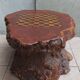 Brutalist chessboard coffee table made from tree stump.