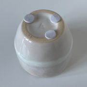 Meeting of three artist's ceramic objects including two pots and a cream covered bowl
