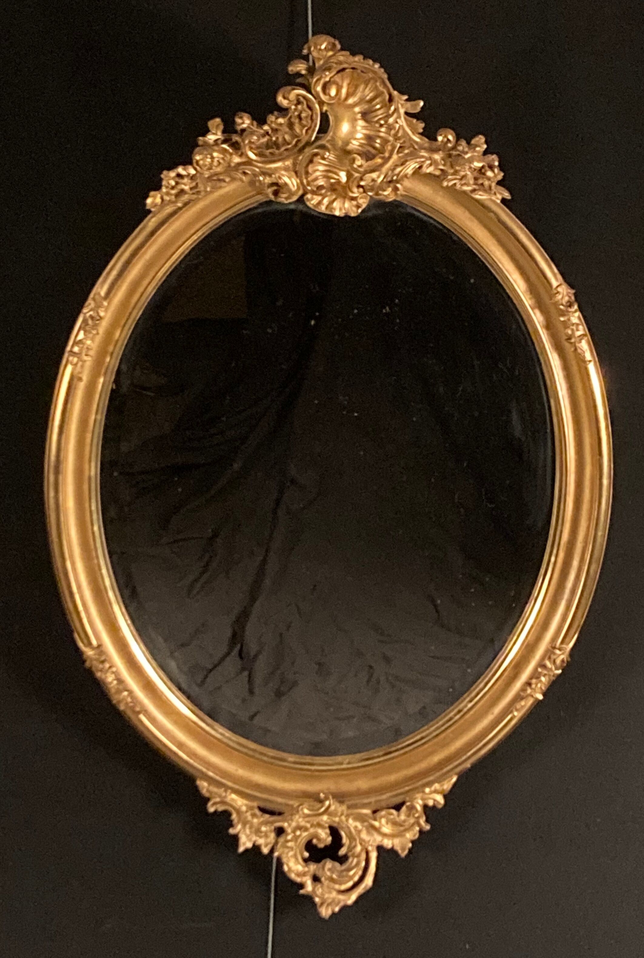 Large oval mirror in gilded wood