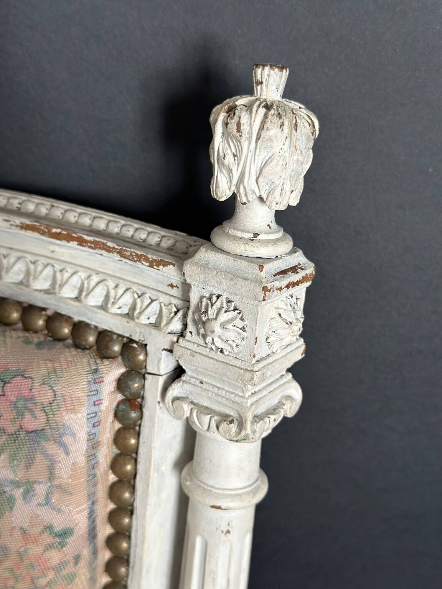 Antique Louis XVI style chair with patinated wood and floral fabric.