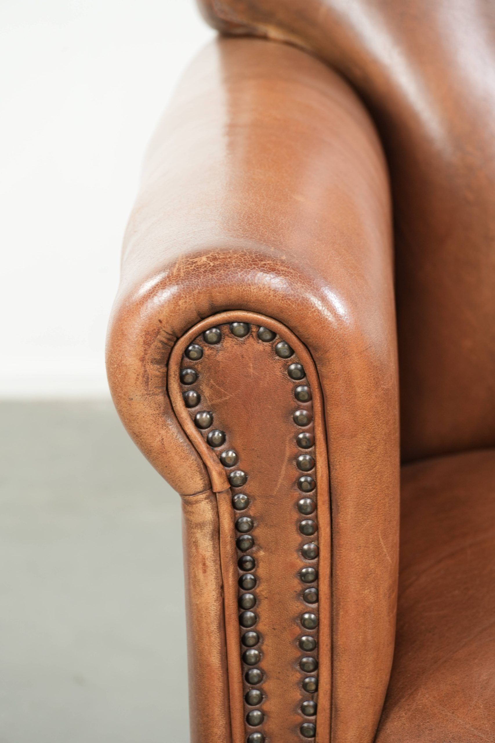 Armchair made of sheepskin leather with refined decorative nail finish