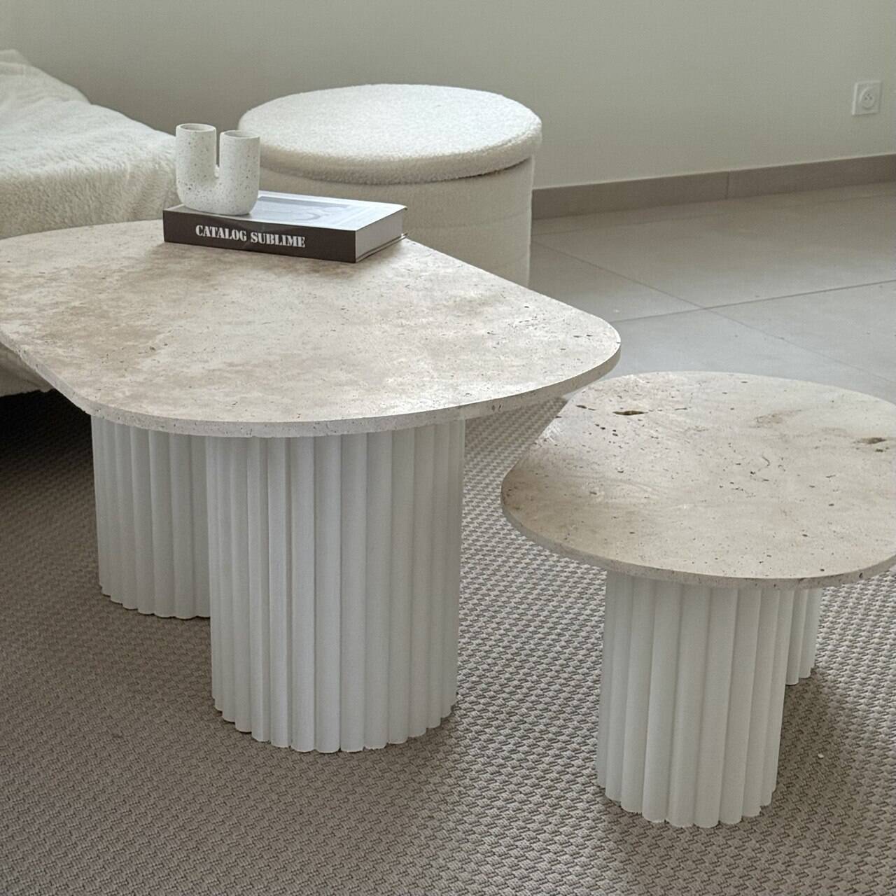 Oval coffee table duo travertine and white fluted wooden legs.
