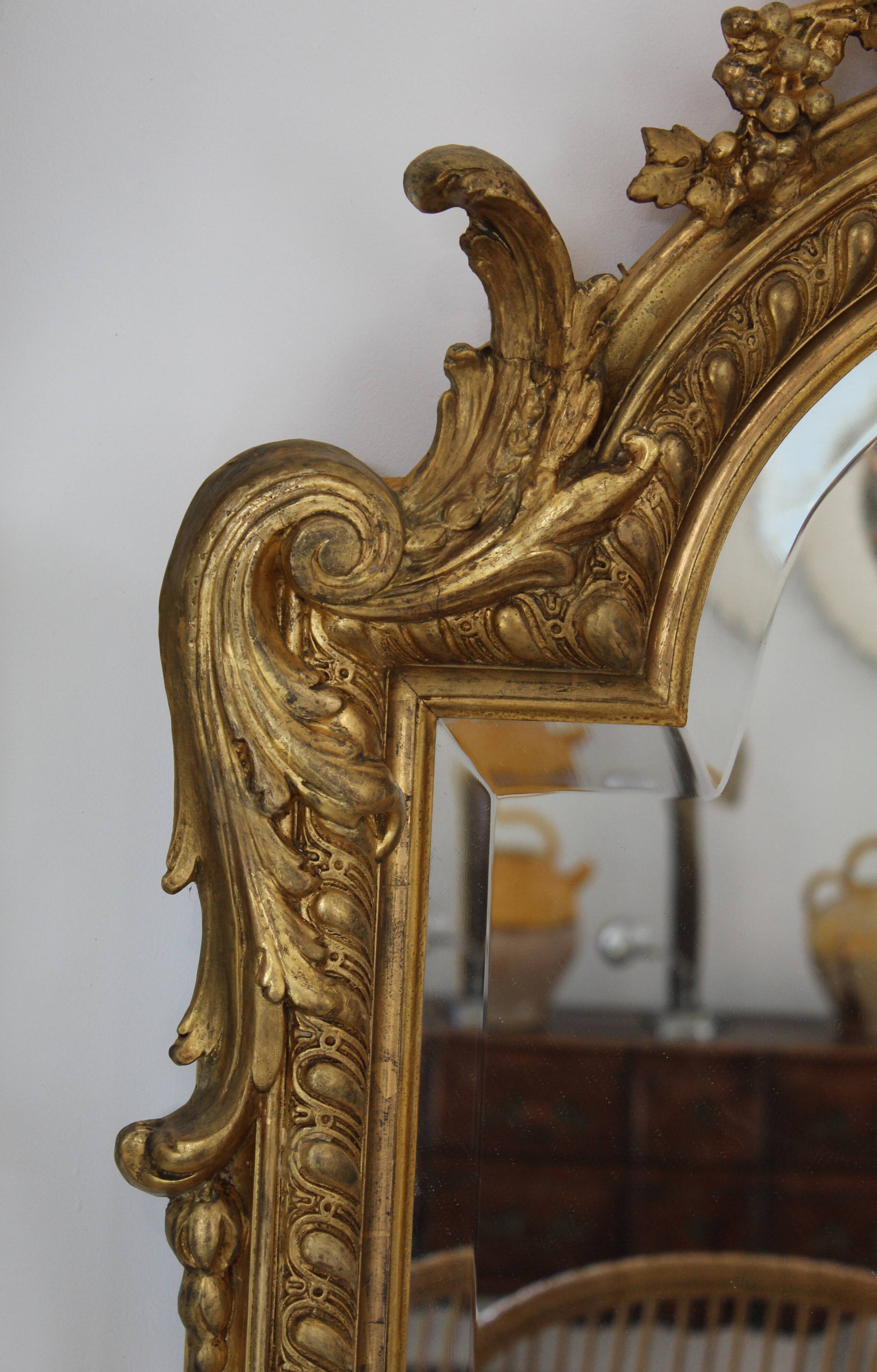 Large 19th-century wooden and gilt-studded mirror decorated with a cornucopia motif.