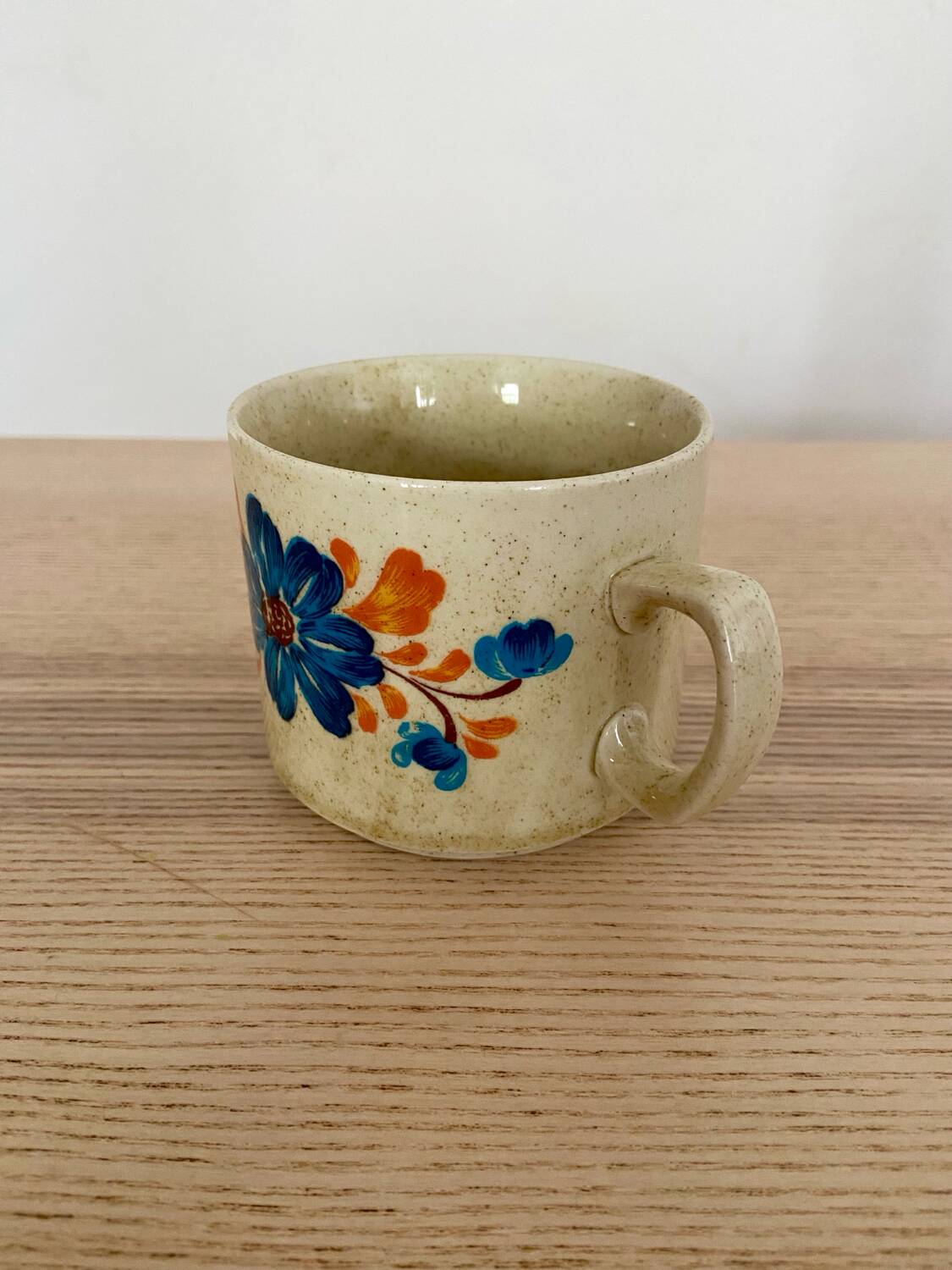 Speckled stoneware cup with blue flower