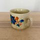 Speckled stoneware cup with blue flower