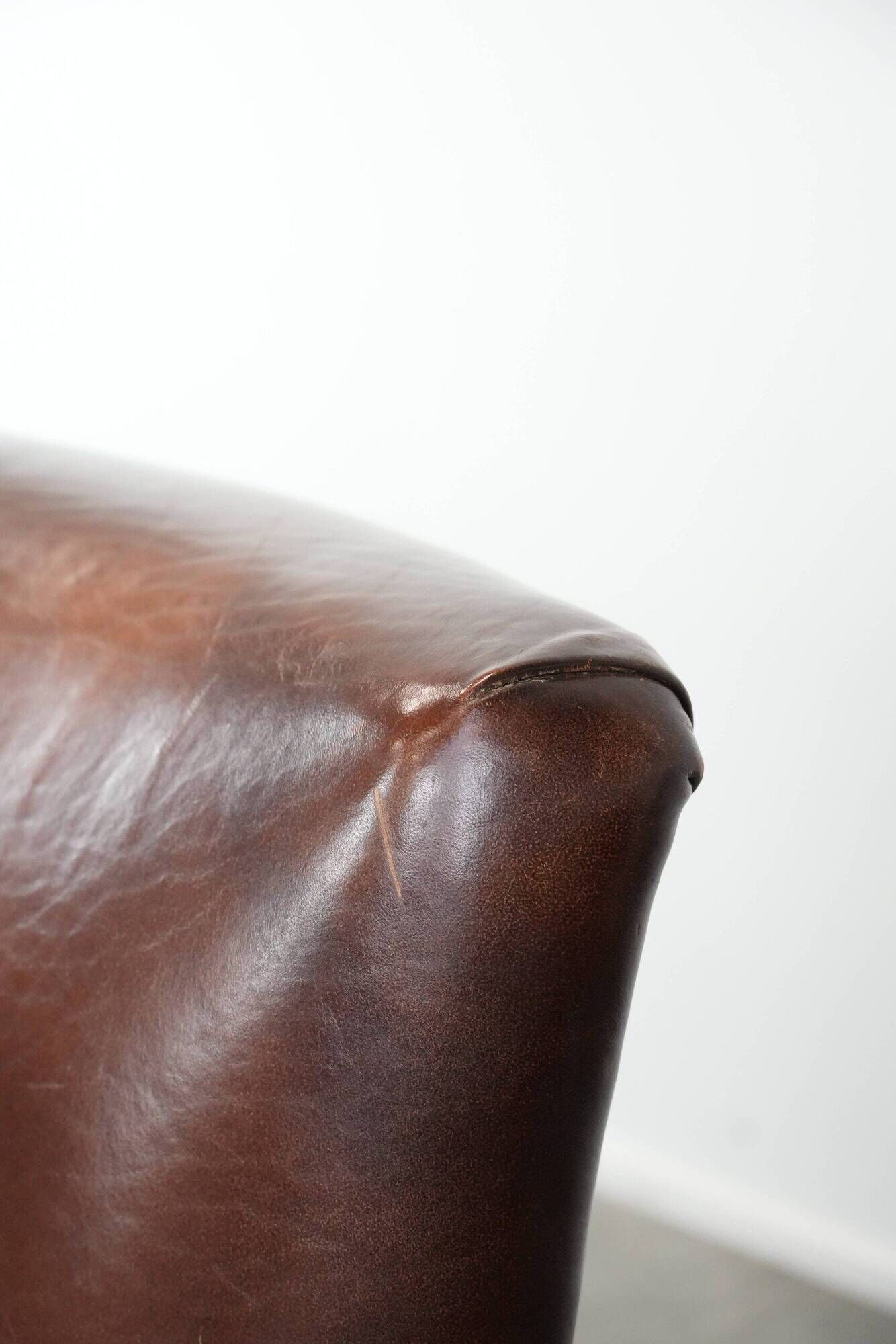 Ensemble de deux fauteuils en cuir de mouton vintage au caractère marqué.