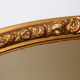 Beveled oval mirror in gilded wood