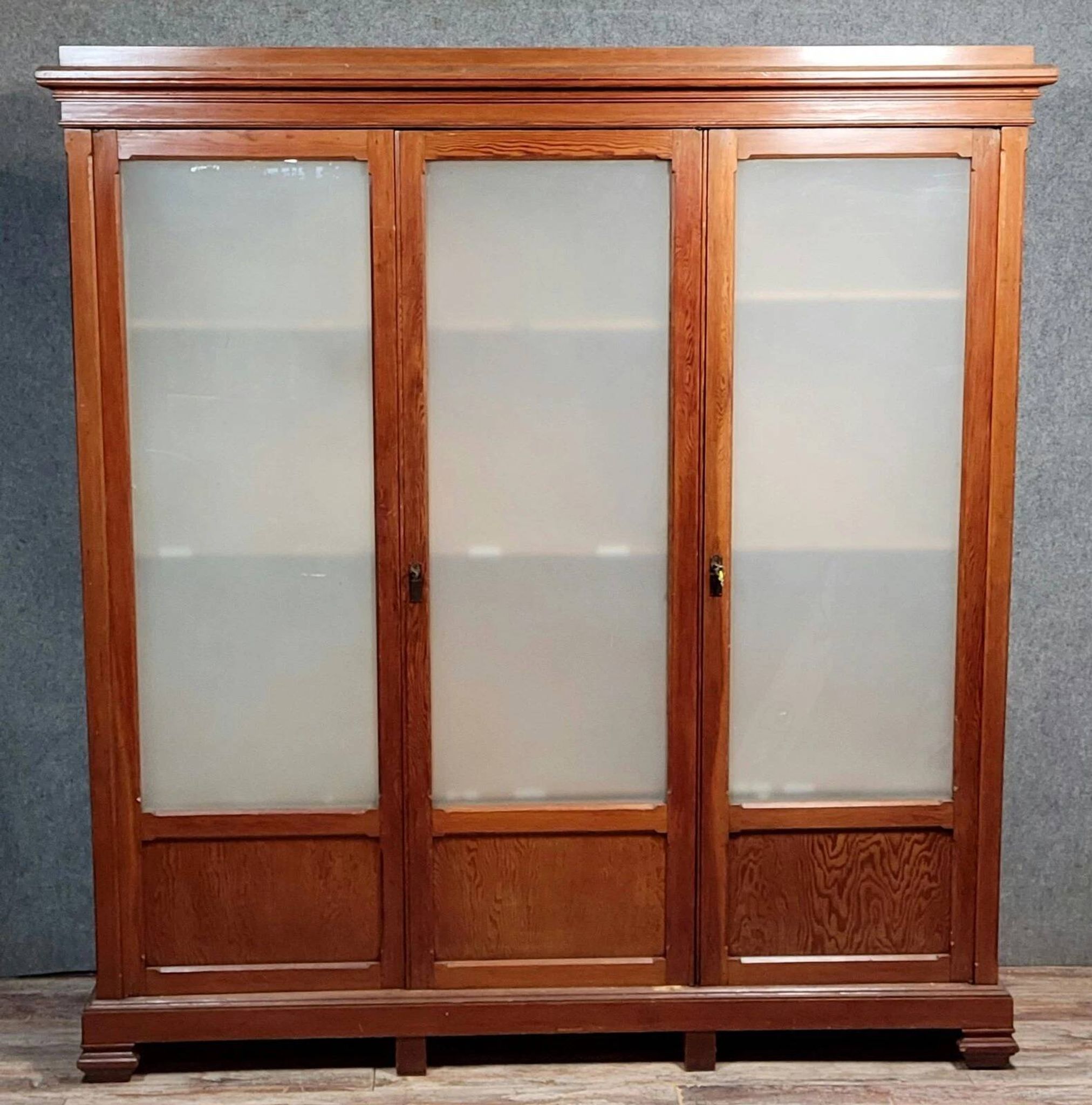 Large pine bookcase with three doors, fitted with frosted glass.