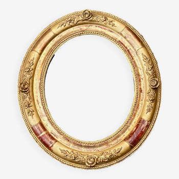 Old golden oval frame decorated with roses