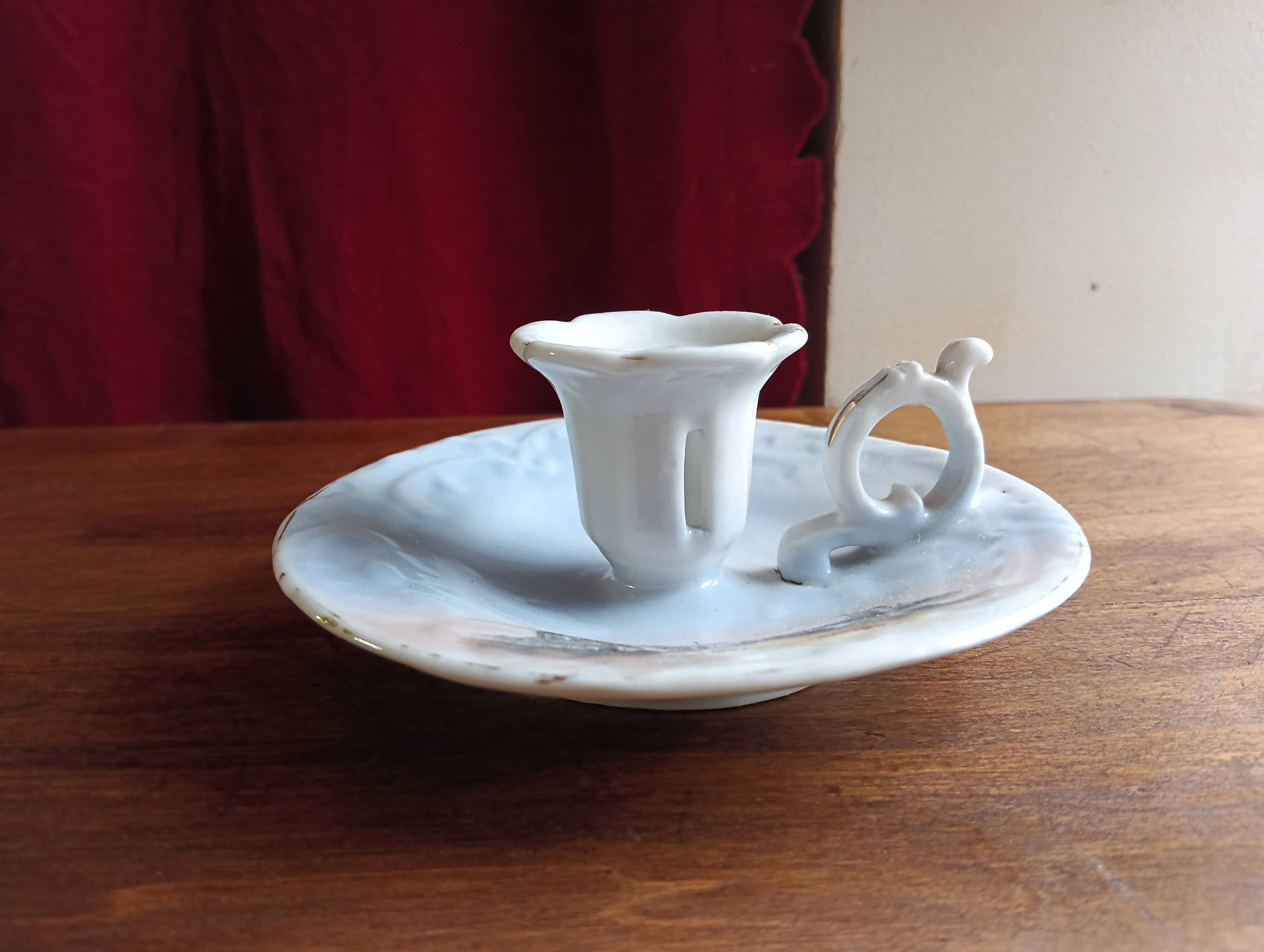 Antique handheld candle holder in porcelain